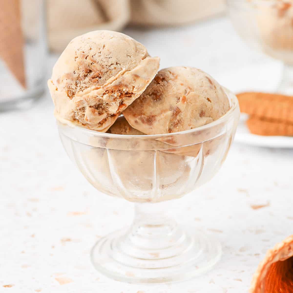 Close up on 3 scoops of ice cream in a glass dessert cup.