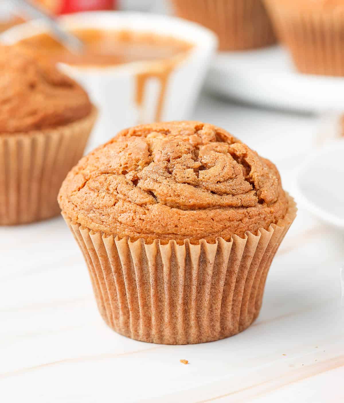 Close up on one muffin on a beige surface.