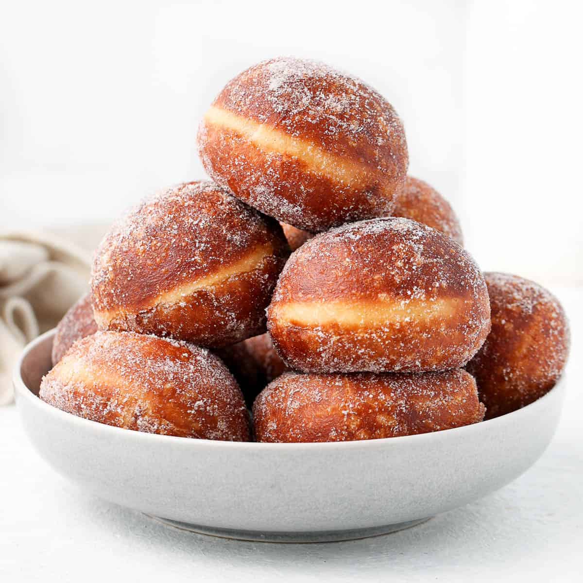 Donuts stacked inside a large grey bowl.