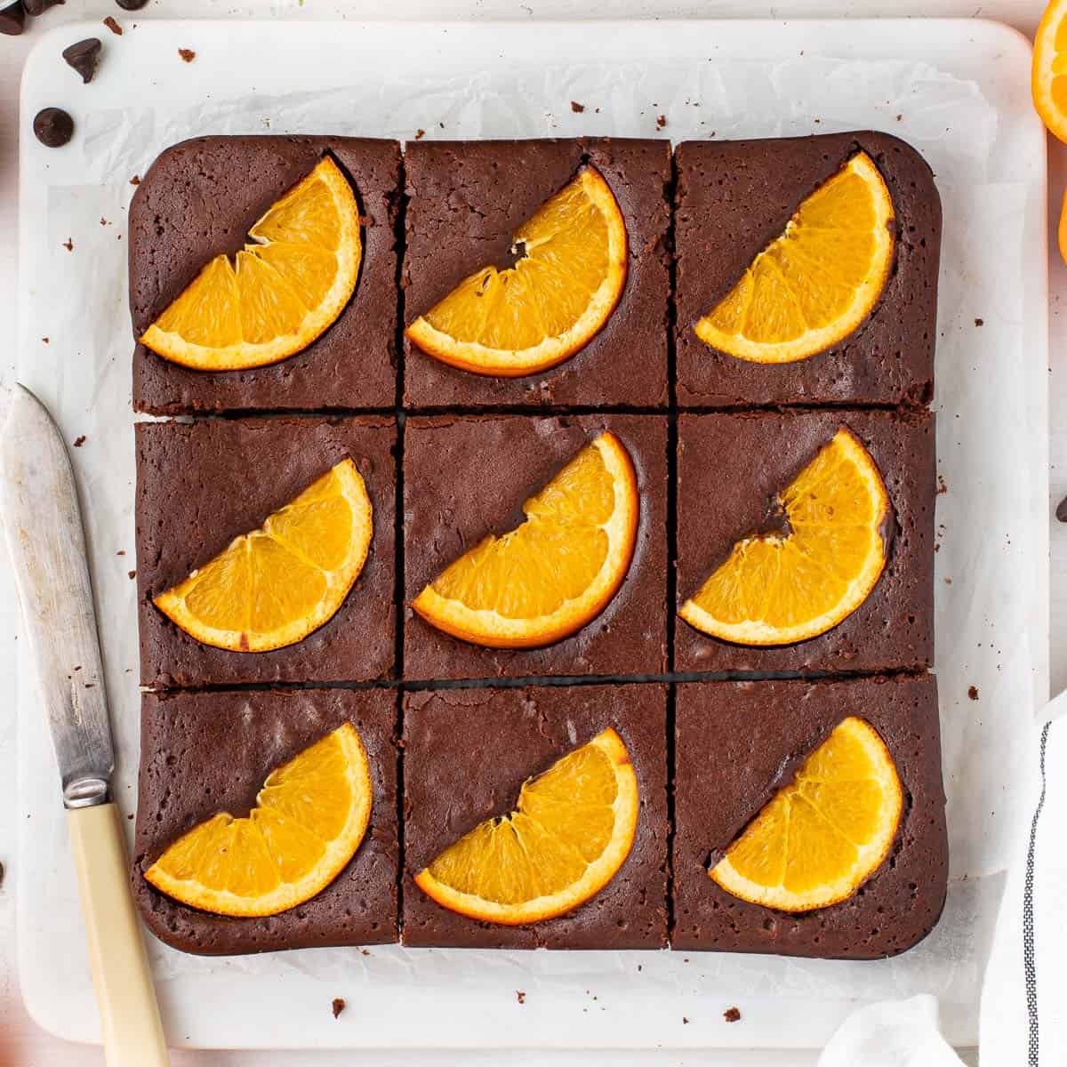 Brownies sliced in 9 on a marble cutting board seen from above.