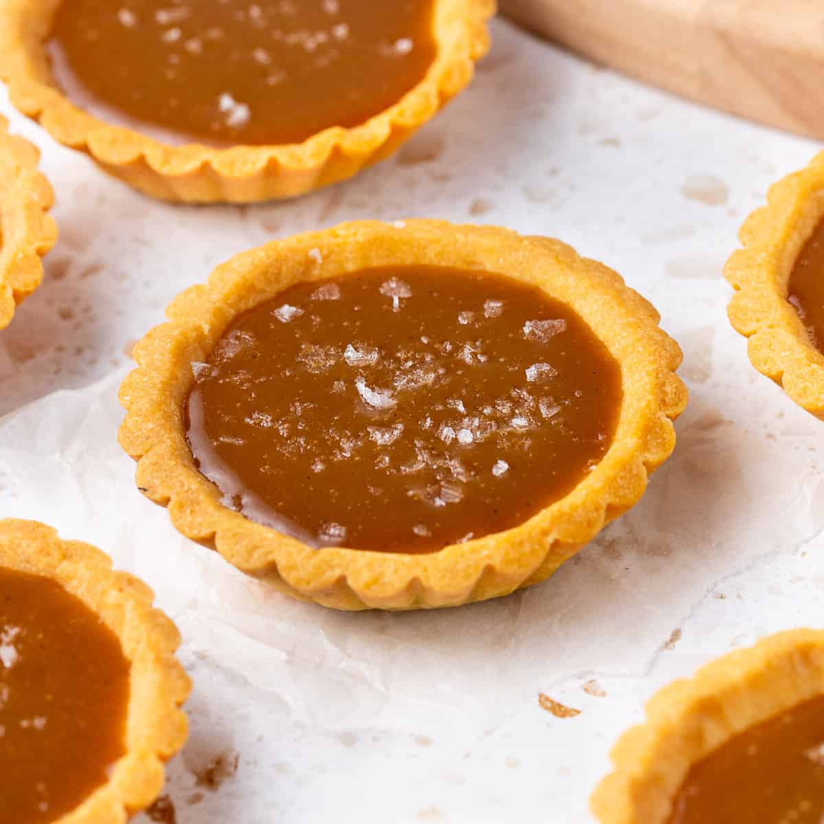 Close up on a tartlet topped with flaky sea salt.