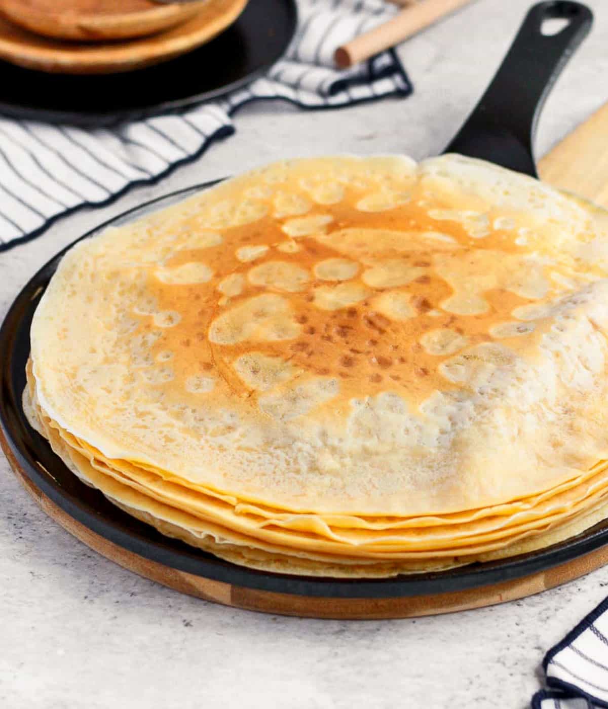 Stack of crepes inside a black crepe pan.