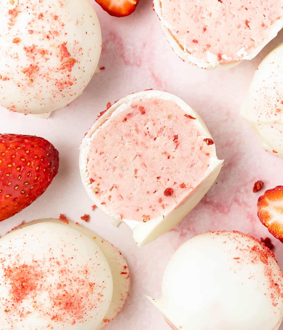 Truffle sliced in half on a pink marble surface seen from above.