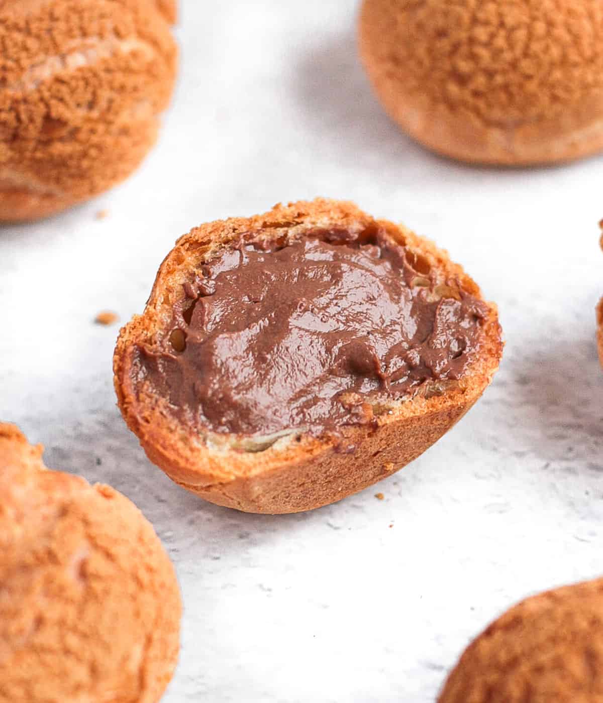 Choux sliced in half and filled with chocolate pastry cream.
