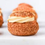 Head on shot of a choux sliced in half and filled with vanilla cream.