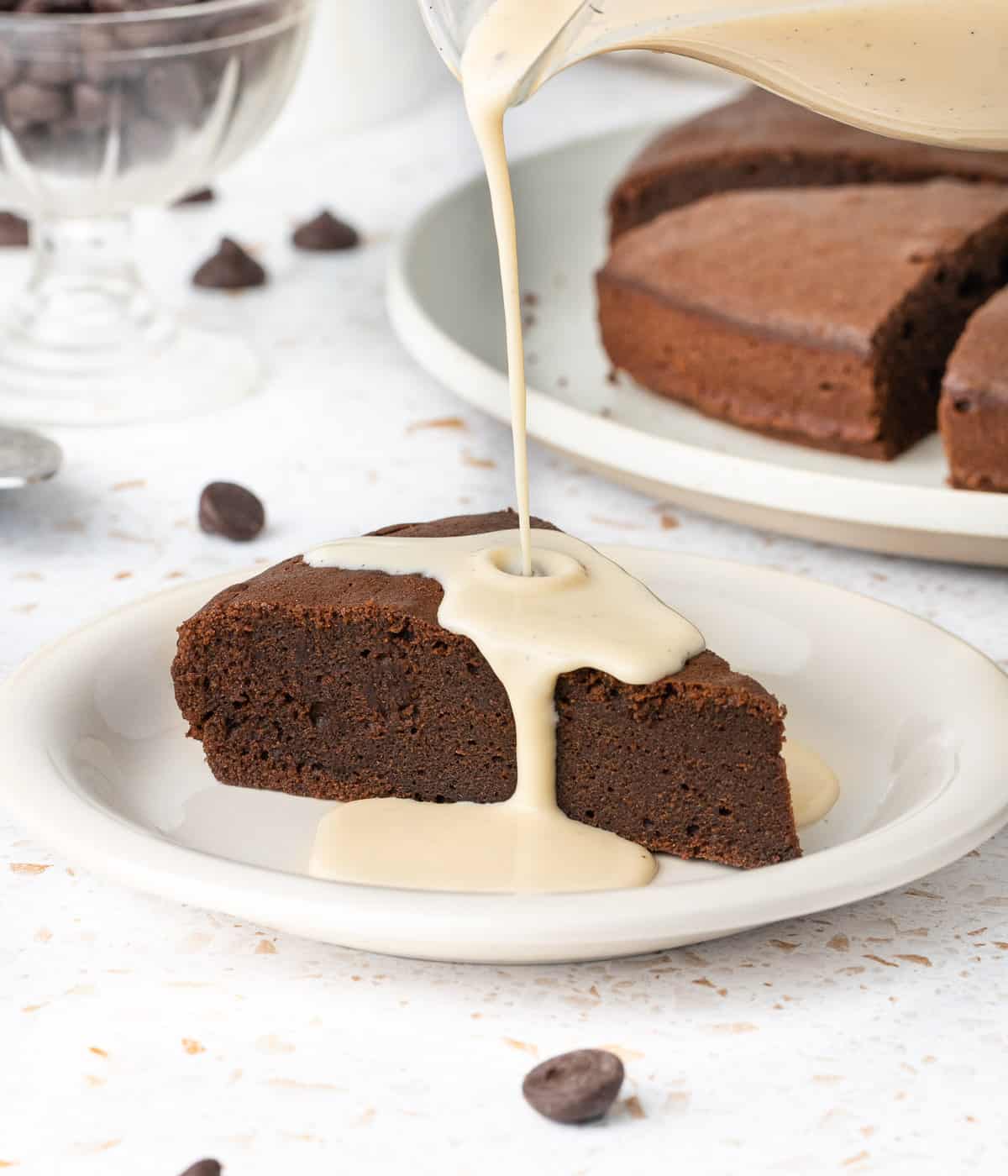 Pouring the custard over a slice of chocolate cake.