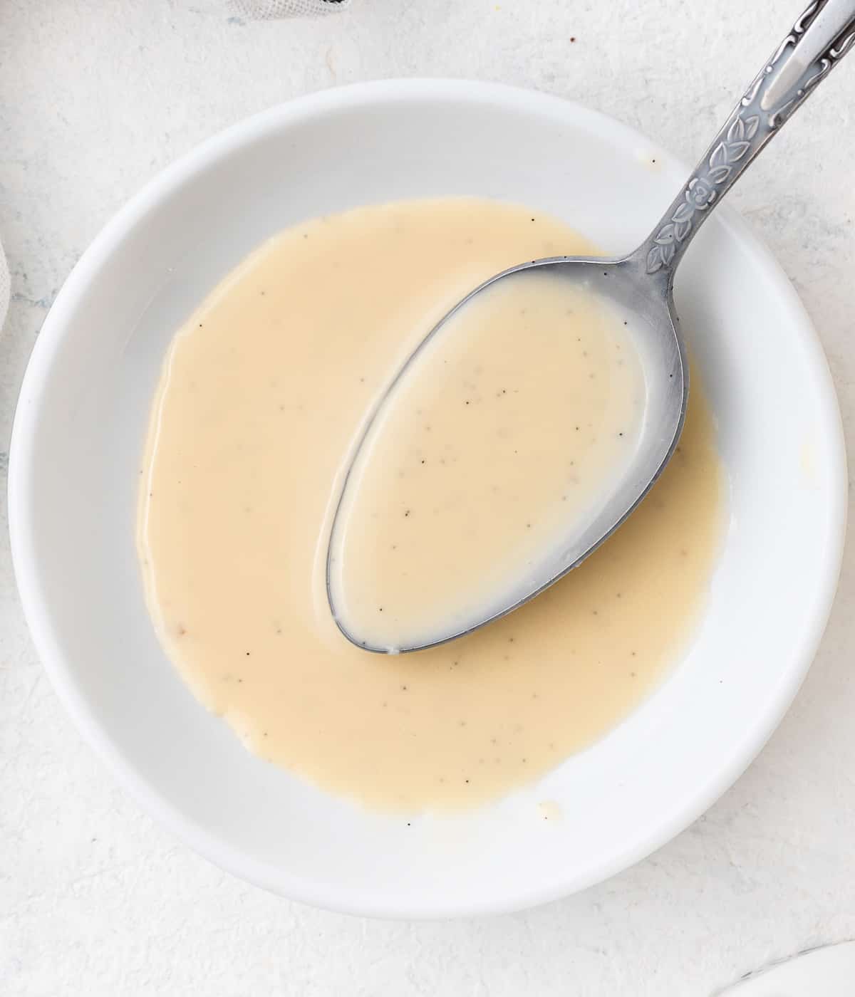 Cream in a small white bowl with a silver spoon.