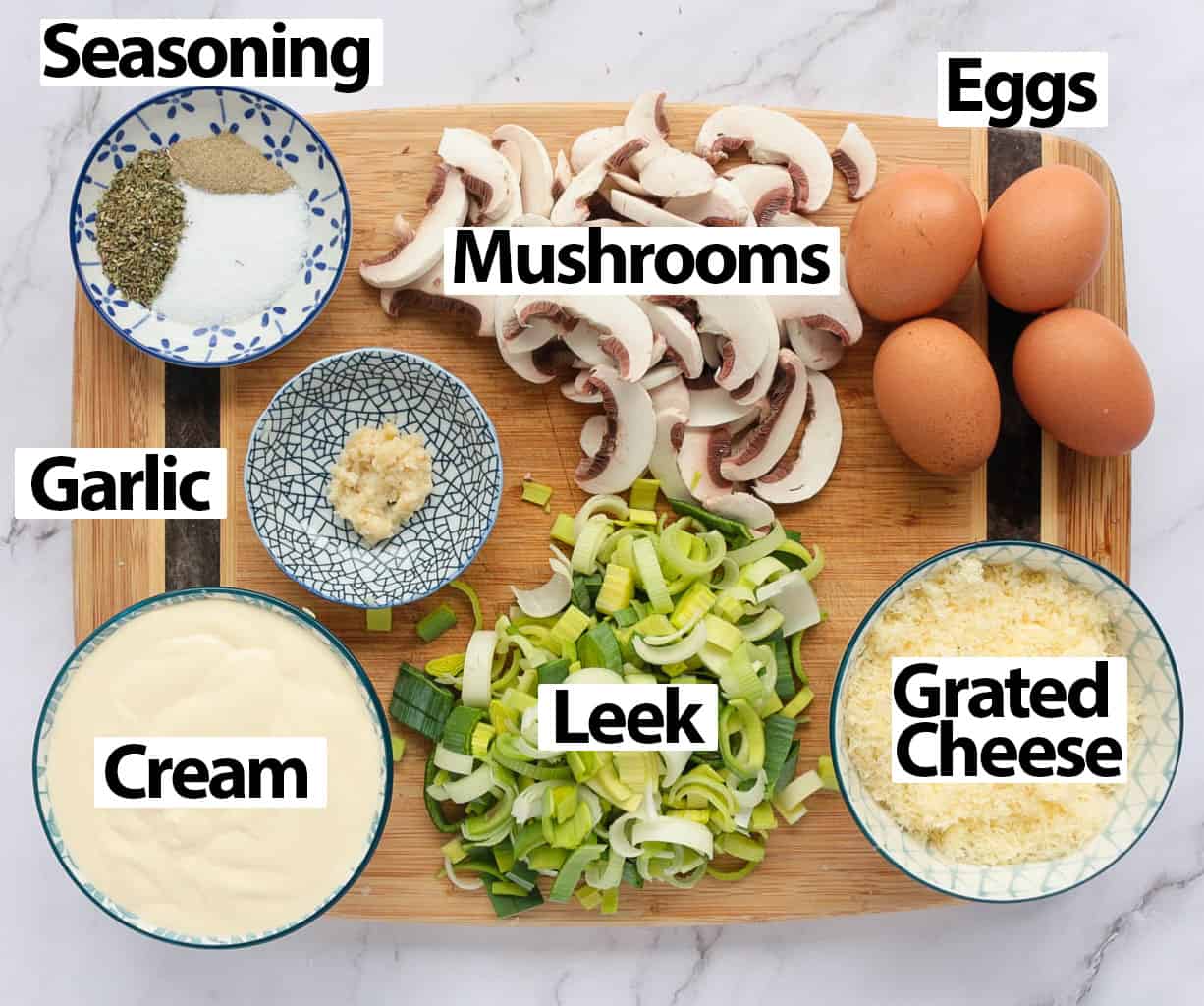 Ingredients for the quiche filling placed over a wooden cutting board.