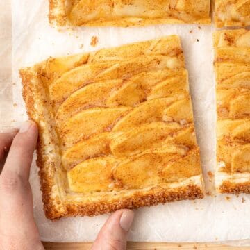 A hand picking up one slice from a cutting board