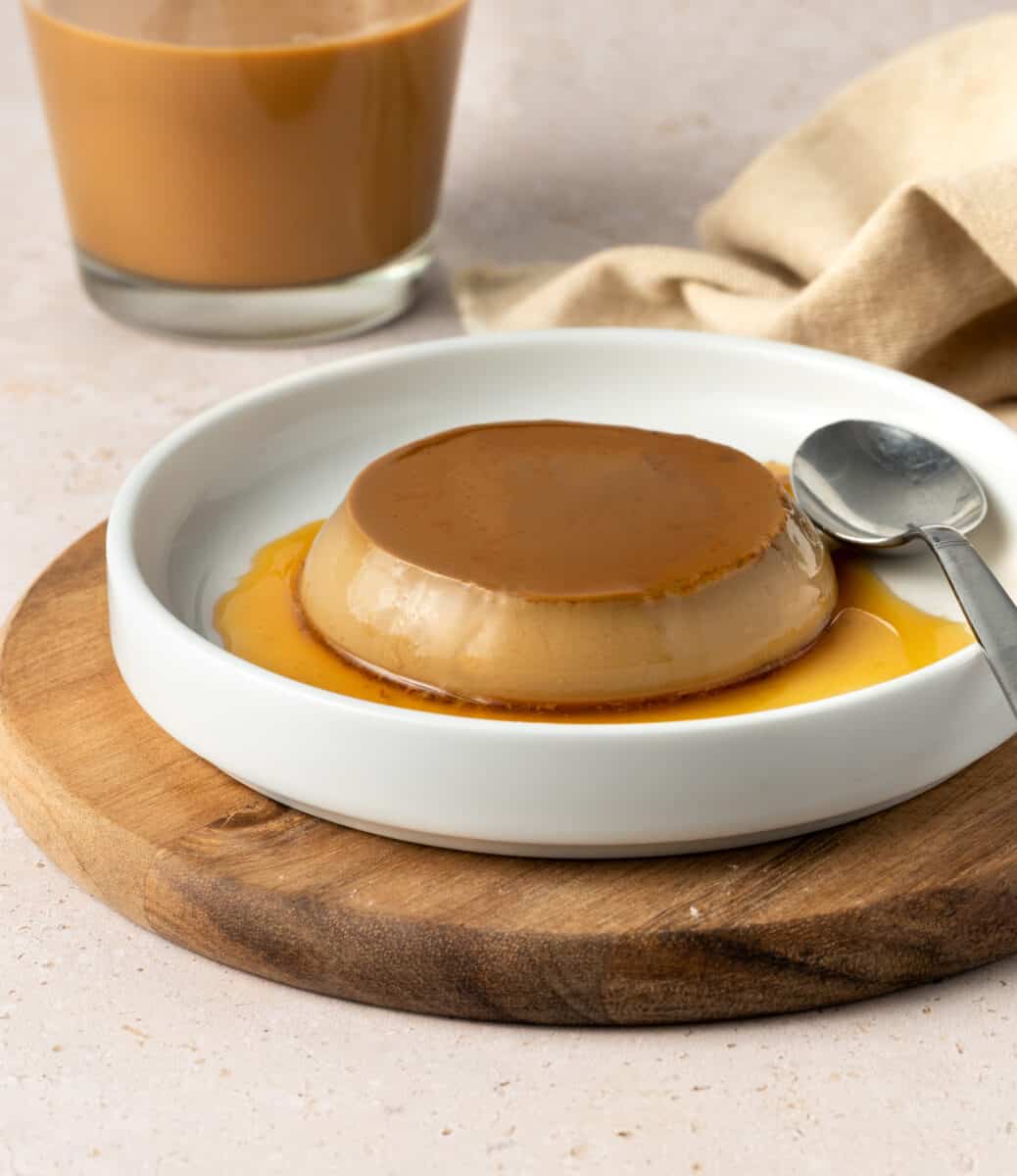 Creme caramel in a small white shallow bowl.