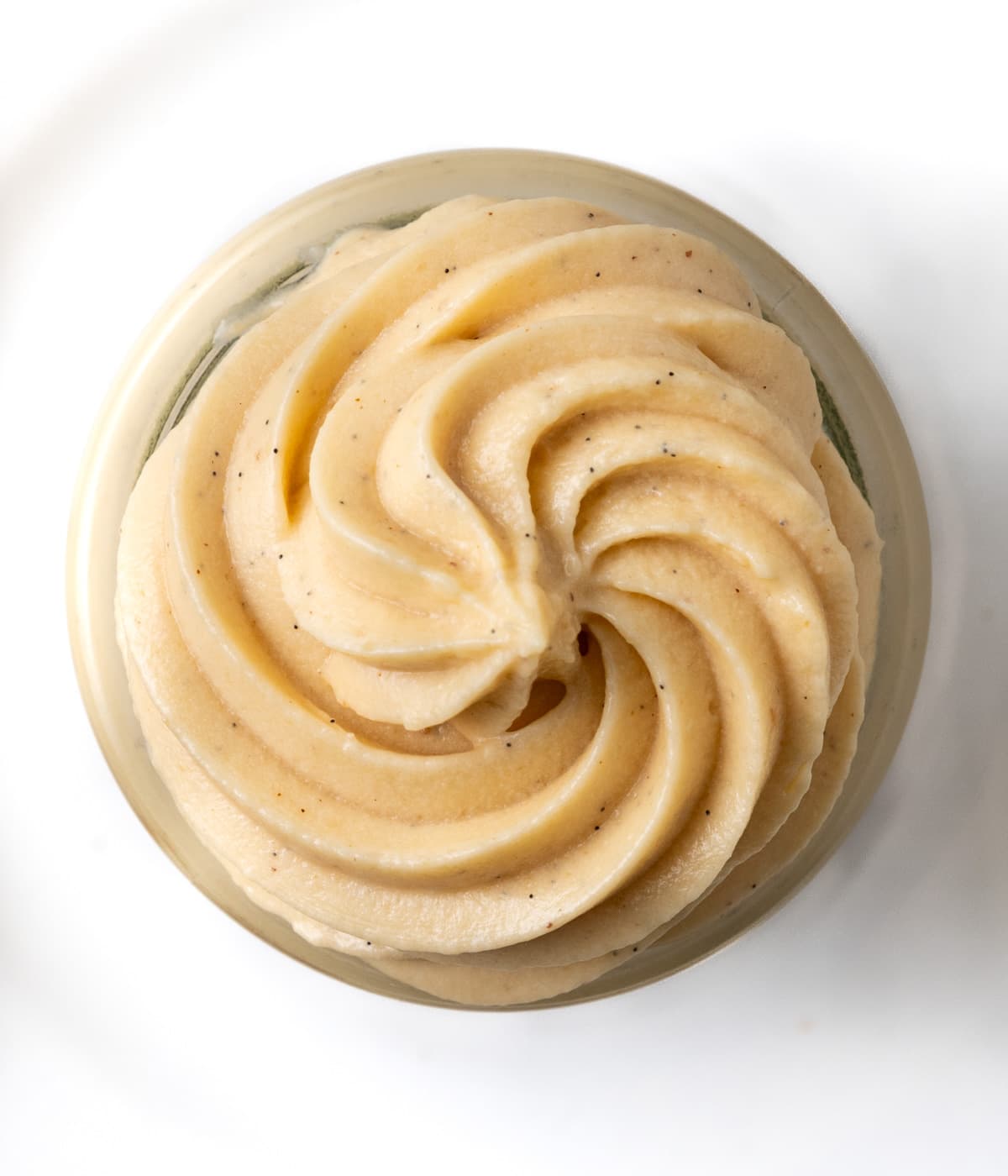 Cream piped inside a round jar seen from above.