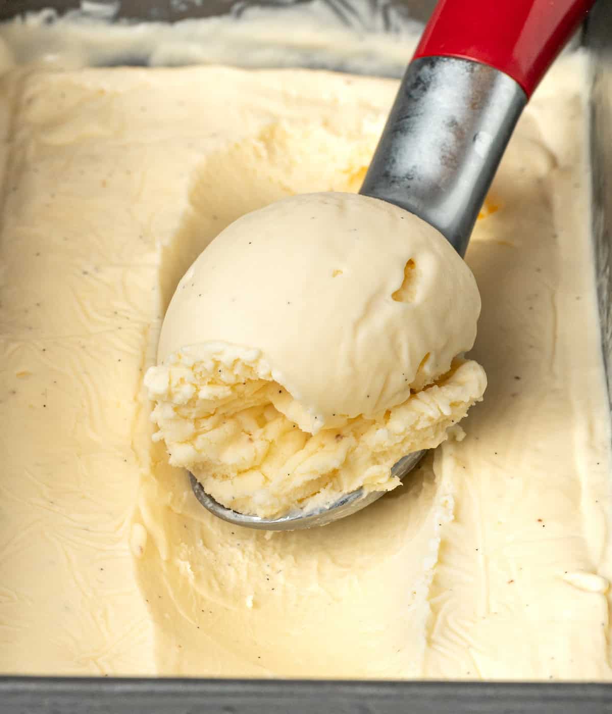 Ice cream scooped over a metal scoop inside the chilled loaf pan.