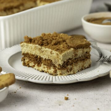 Close up on a slice of speculoos tiramisu on a small white plate.