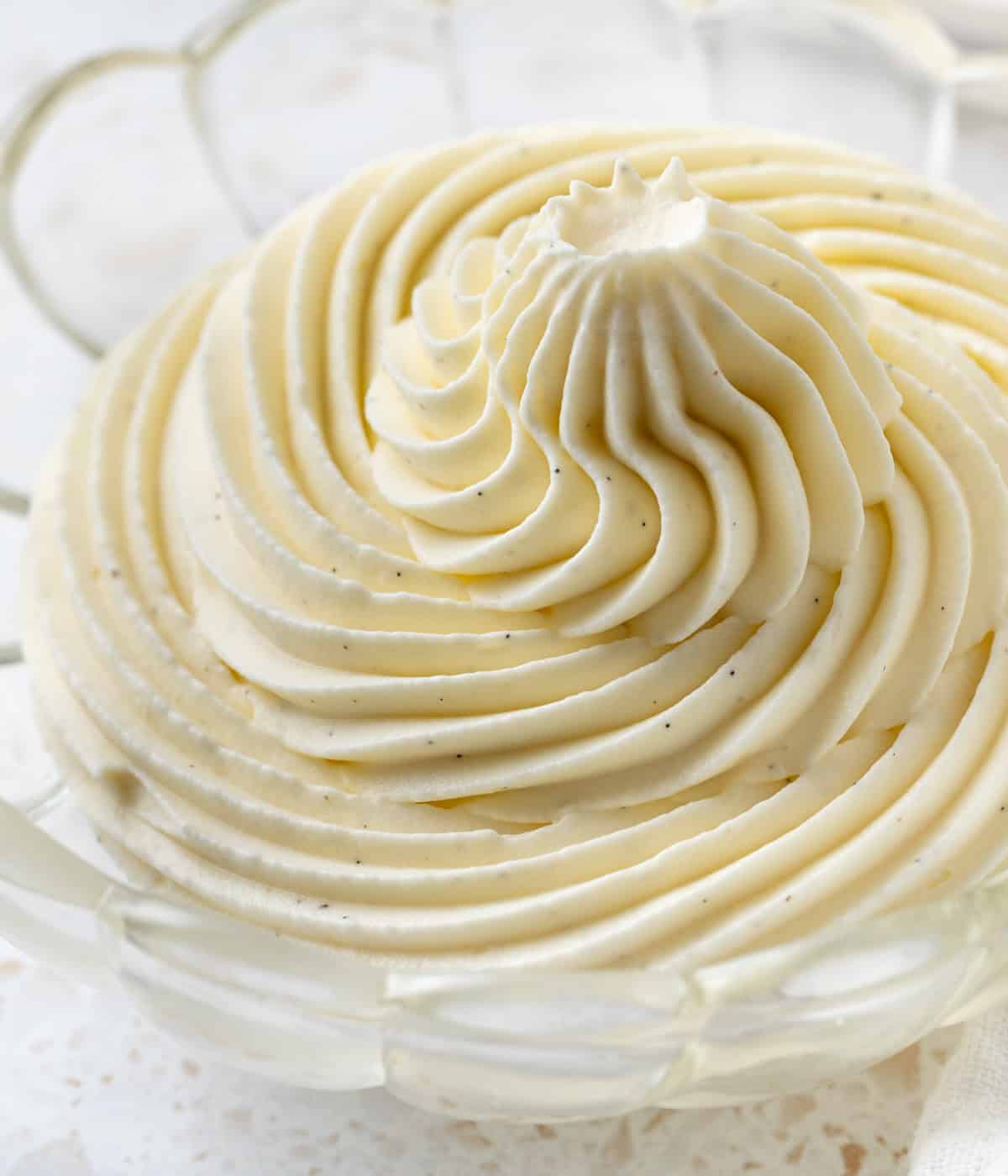 Close up on the whipped cream piped inside a small glass bowl.