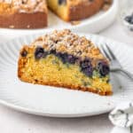One slice of cake on a small white plate with a silver fork.